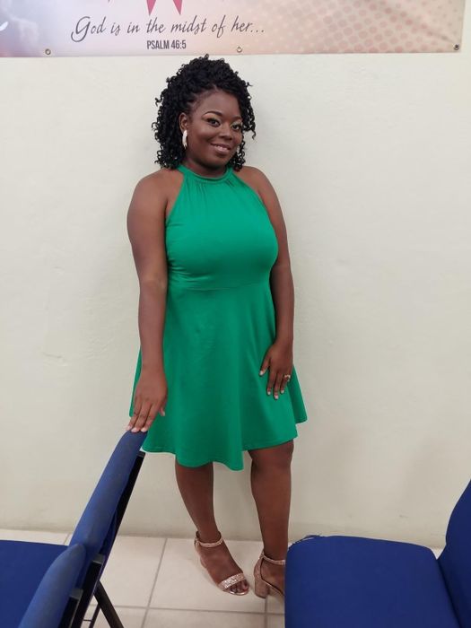 The reviewer is seen wearing a stunning green dress, exuding a fresh and stylish vibe.