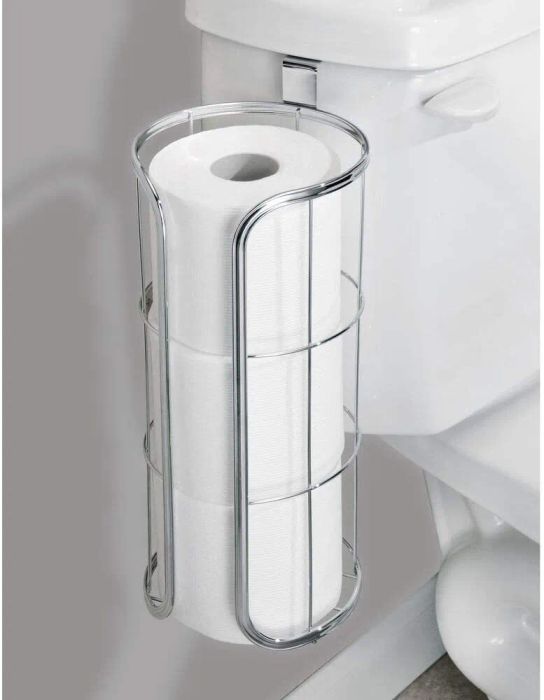 The holder is attached to the toilet tank, neatly holding three rolls of toilet paper.
