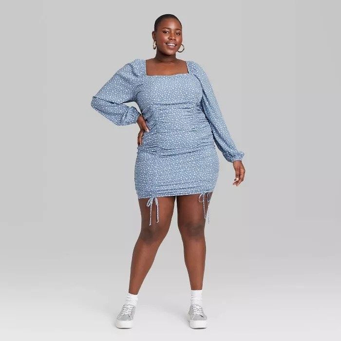 The model is seen wearing an elegant blue dress, showcasing its timeless appeal.