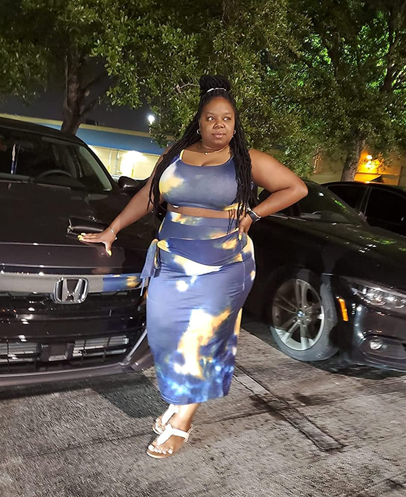 Reviewer styled in a grey and yellow patterned two-piece set with white sandals.