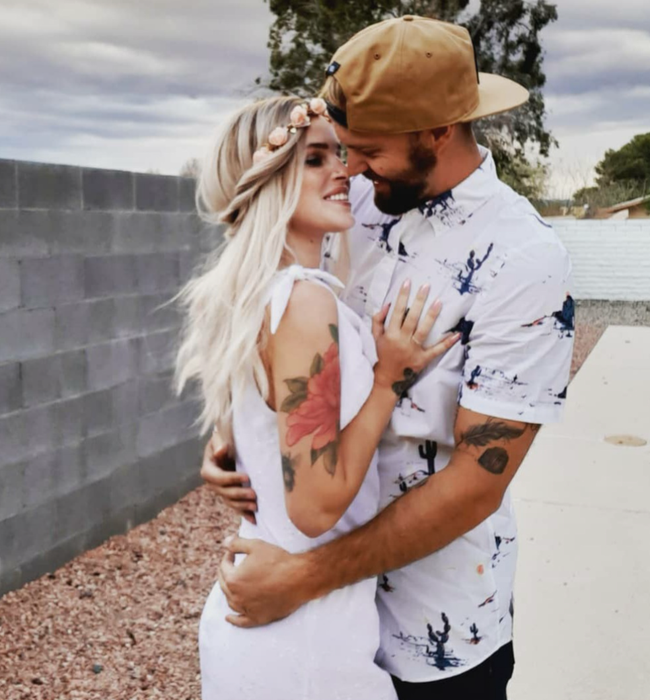 A reviewer shared a photo of two people embracing, one of whom is wearing a white short-sleeve button-down shirt adorned with a cactus pattern throughout.