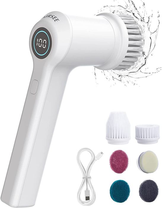 A white electric scrubbing brush accompanied by six interchangeable heads and a charging cord