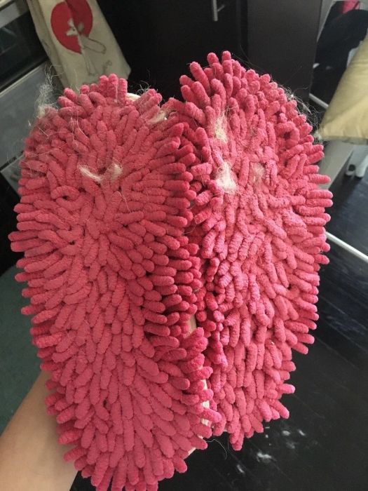 Mytour editor holding the bottoms of hot pink sweeper slippers, which have collected some dust and fuzz