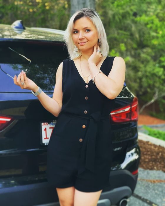 Reviewer is wearing a black tank romper with buttons down the front