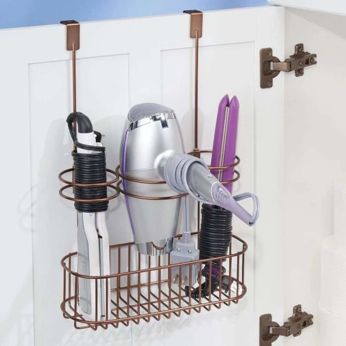 A brass-colored storage rack holding a hair dryer, flat iron, and curling iron
