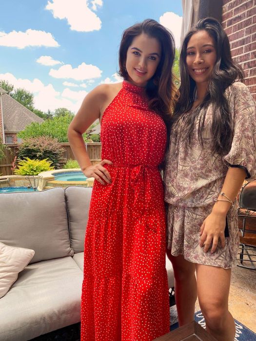 Reviewer is wearing a red halter neck maxi dress with small white polka dots scattered all over.