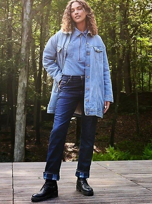 A model wearing fleece-lined jeans outdoors in a forest setting