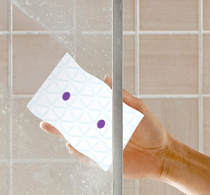 Demonstrating the product's effectiveness on shower doors