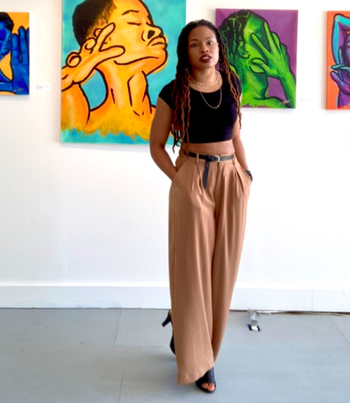 A reviewer wearing beige palazzo pants with black heels and a black top