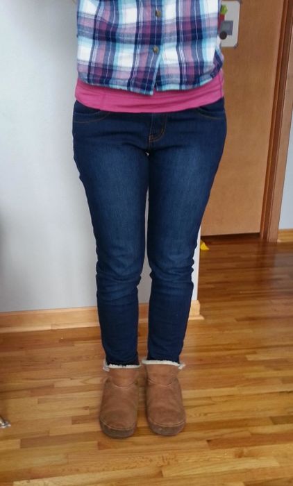 A reviewer’s bottom half, wearing jeans paired with Ugg slippers