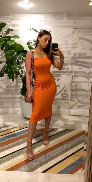 Reviewer modeling the dress in a striking orange hue