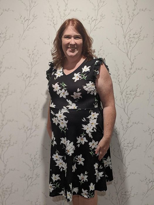Reviewer in a black and white floral dress