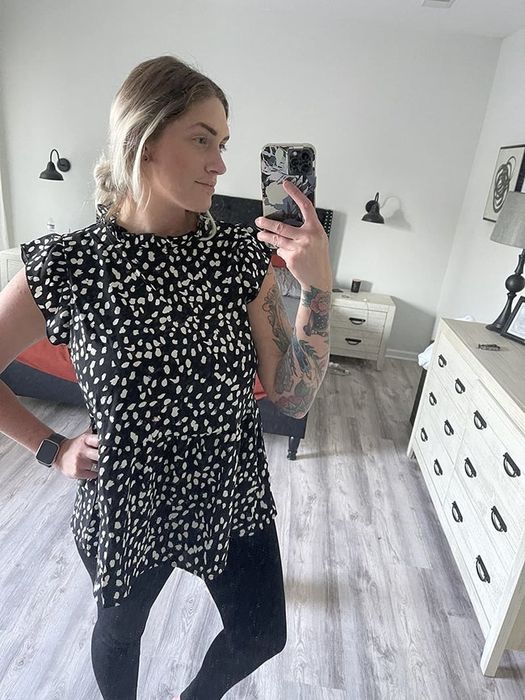 The reviewer is wearing a black and white spotted top.