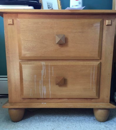 A photo from the reviewer showing a light wood nightstand with white stains dripping down the front.