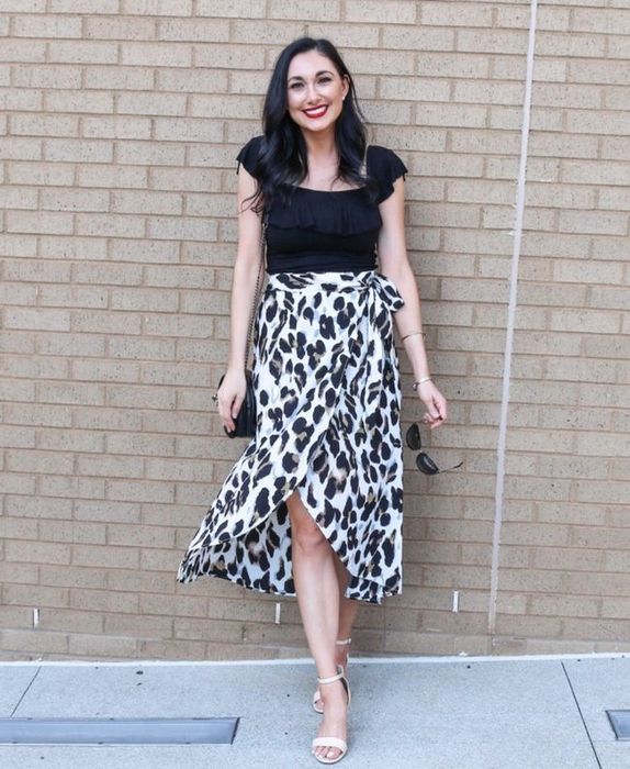 A photo of a reviewer wearing a leopard print skirt paired with a black top