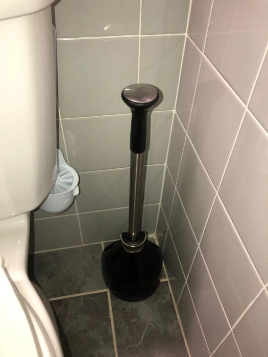 The toilet brush is positioned upward, making it nearly invisible.
