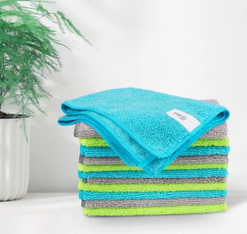 Blue, green, and gray microfiber cleaning cloths are neatly arranged on the side of a table.