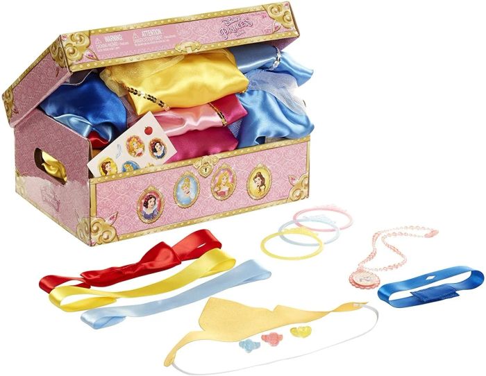 A partially opened pink trunk displaying folded costumes inside, surrounded by accessories