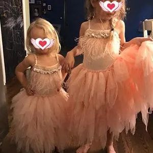 A reviewer's photo of two children wearing the dusty pink tutu dresses