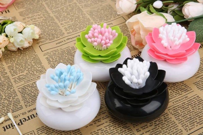 Four pots with lily flowers on top, each designed to hold cotton swabs in a lovely way.