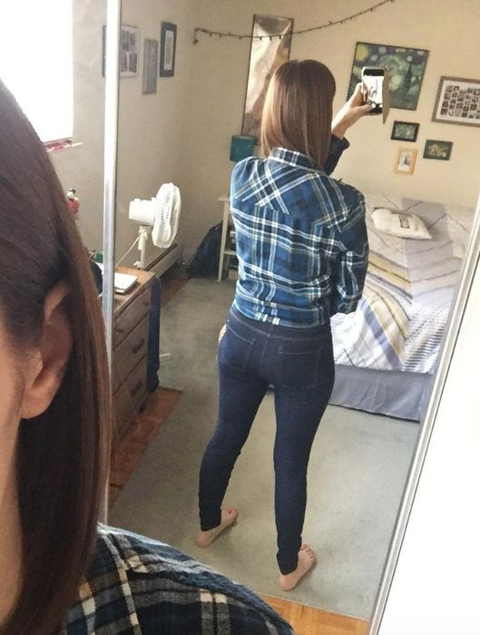 A reviewer from behind, sporting dark wash jeggings and a blue plaid shirt for a complete, trendy look.