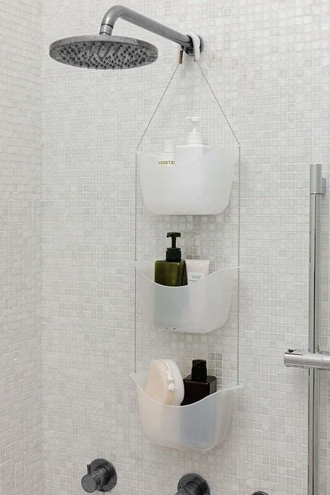 Shower caddy hanging inside the shower, neatly holding bottles in place.
