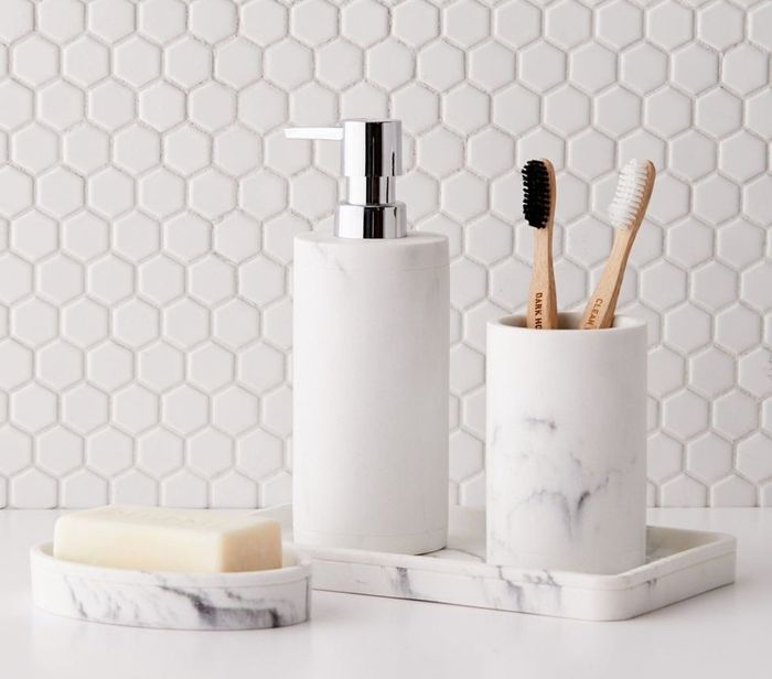 The elegant white and grey faux marble set arranged on a bathroom countertop.