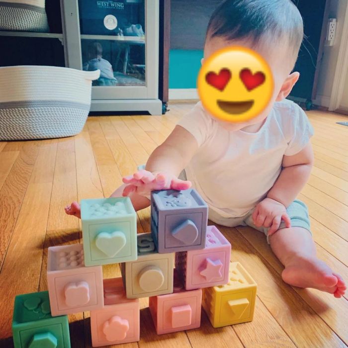 A review photo of a baby playing with the stacked pastel blocks