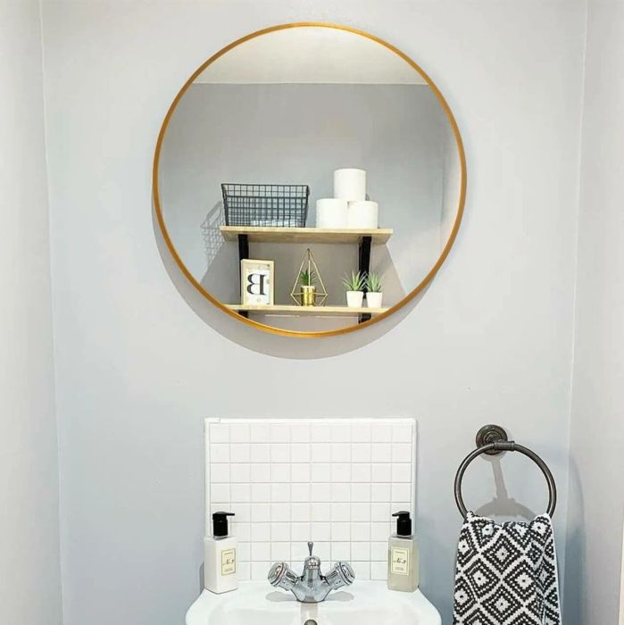 Gold-accented mirror above sink