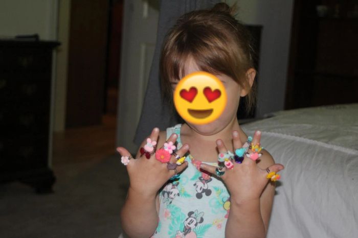 A reviewer's photo of a child wearing all 24 rings on their fingers