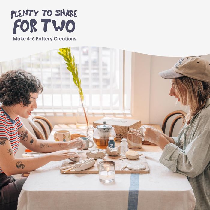 Two people sitting at a table creating pottery with a pottery set, titled