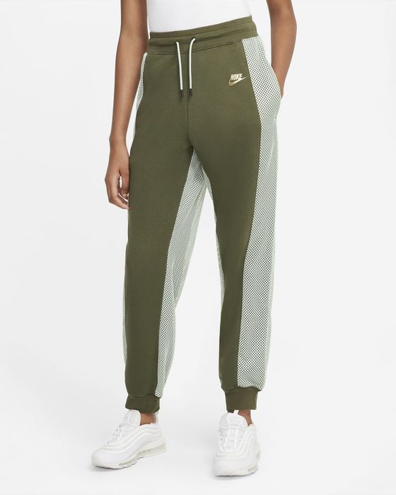 Model dressed in green sweatpants paired with white sneakers