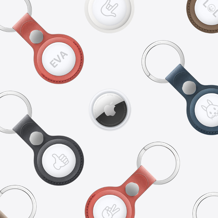 A close-up of several AirTags with emojis etched into them