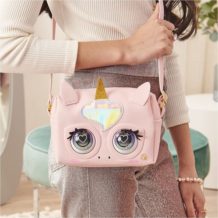 A child proudly wearing the unicorn purse pet