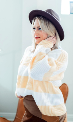 a model sporting the sweater with light yellow and white stripes running vertically