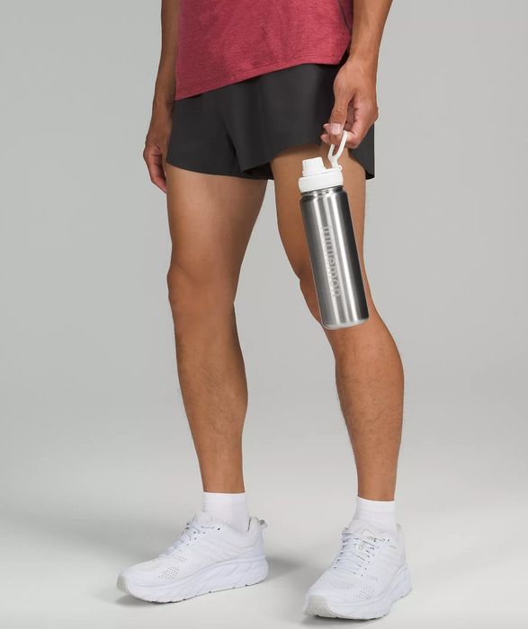 A model holding a silver water bottle with a white cap