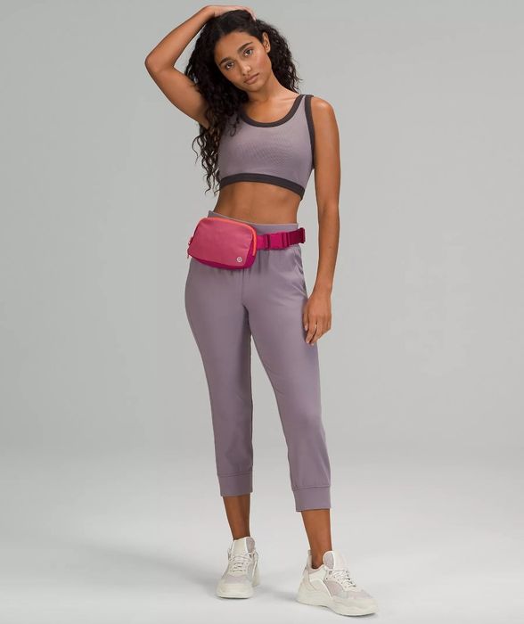 A model wearing a pink belt bag with a purple outfit