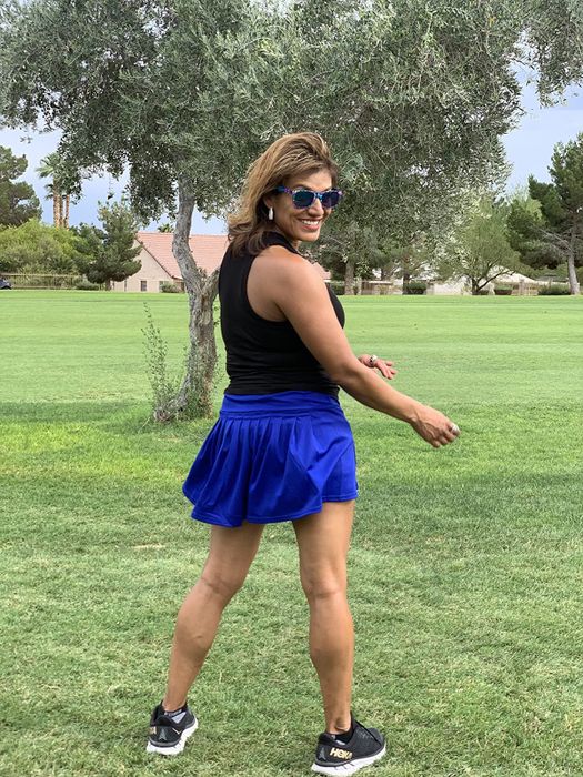 A reviewer wearing the pleated tennis skirt in blue