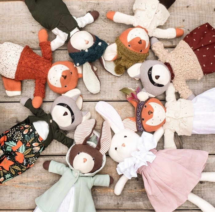 An assortment of stuffed animals in clothing arranged in a circle