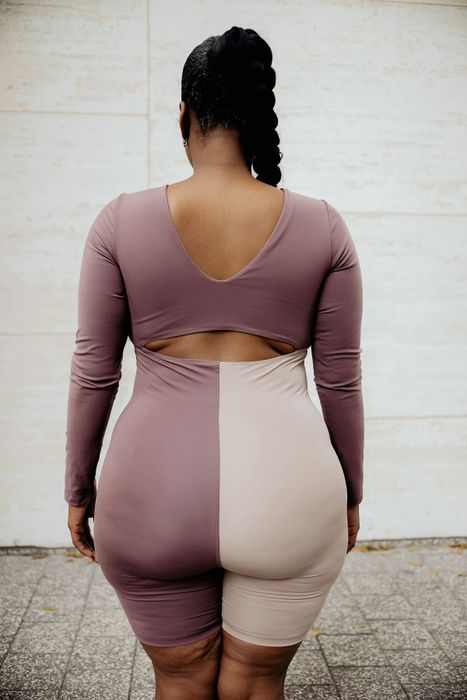 The same model is showing the back of the bodysuit, highlighting the cut-out design in the middle.