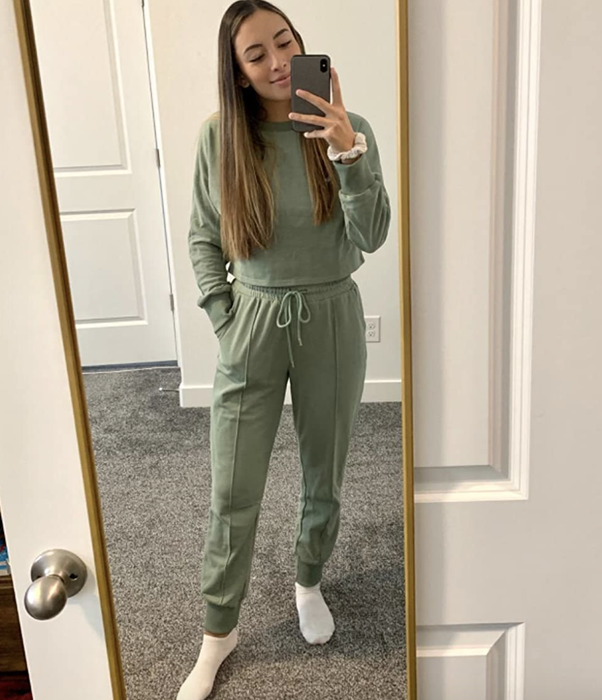 A reviewer sporting olive green drawstring pants paired with a matching crewneck sweater with sleeves