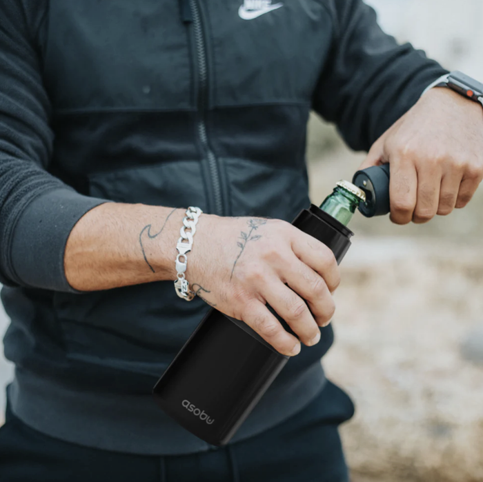 A close-up of someone using their insulated can cooler outdoors
