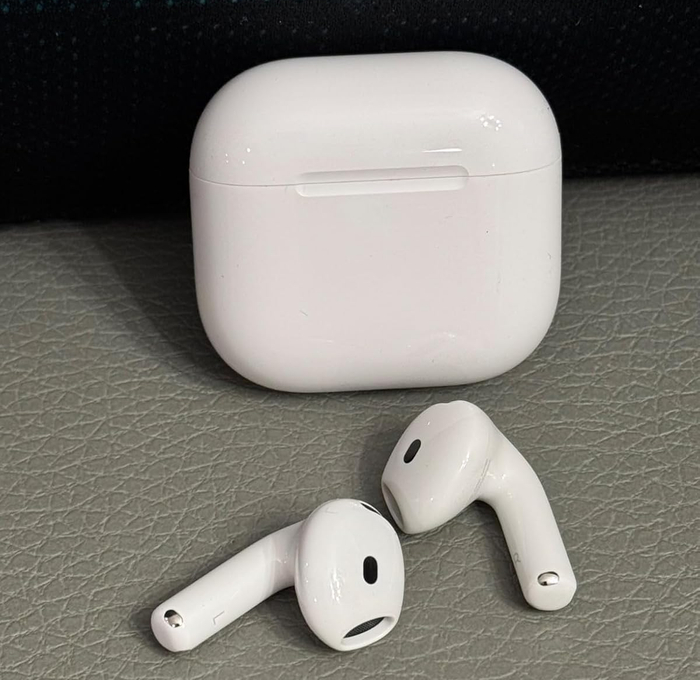 White wireless earbuds alongside a charging case resting on a textured surface, highlighted in a shopping article.