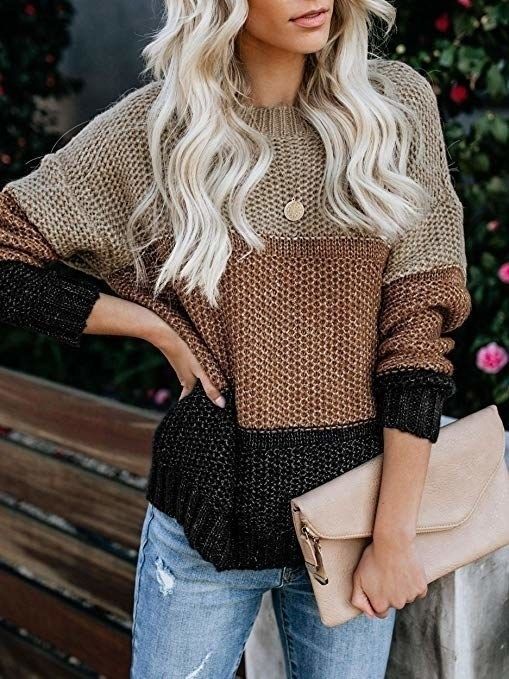 A model showcasing a knit sweater, with a light tan top, a darker brown middle, and a black bottom.