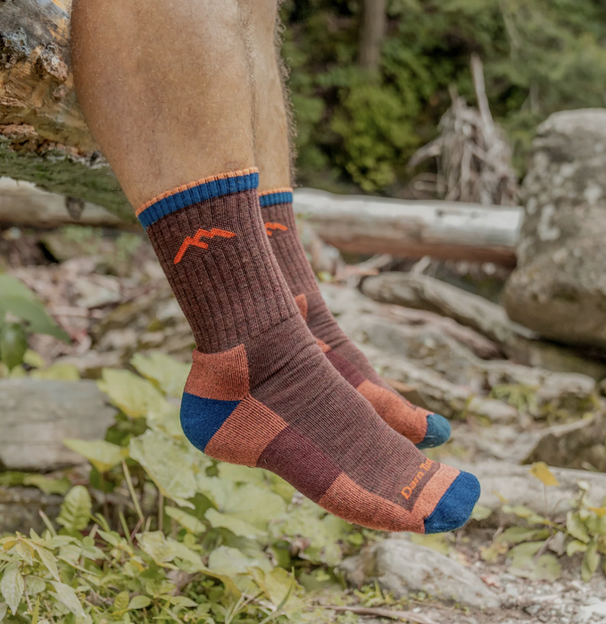 A close-up of someone's maroon socks while relaxing on a hike