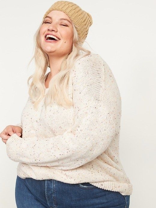 a model in a cream-colored sweater with speckles throughout
