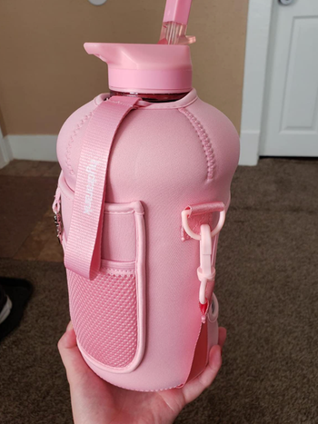 A reviewer showing off a pink hydrojug water bottle