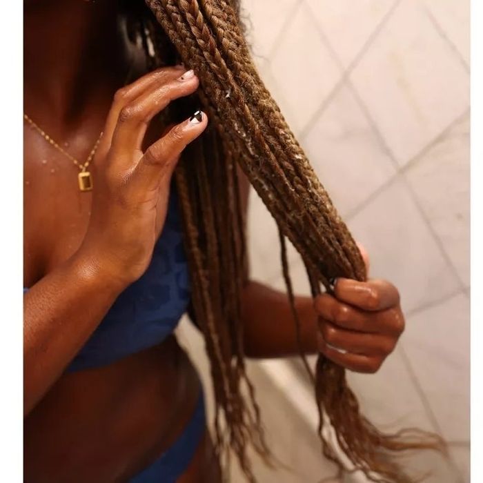 A person massaging the conditioner into their braided hair.