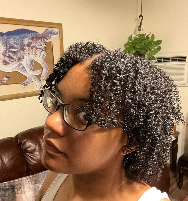 A reviewer showcasing moisturized, defined coils.