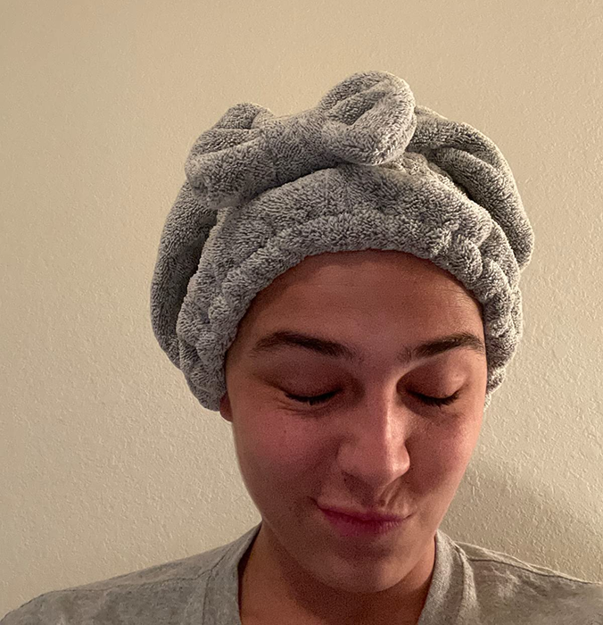 An image capturing a reviewer wearing a cozy grey hair towel.